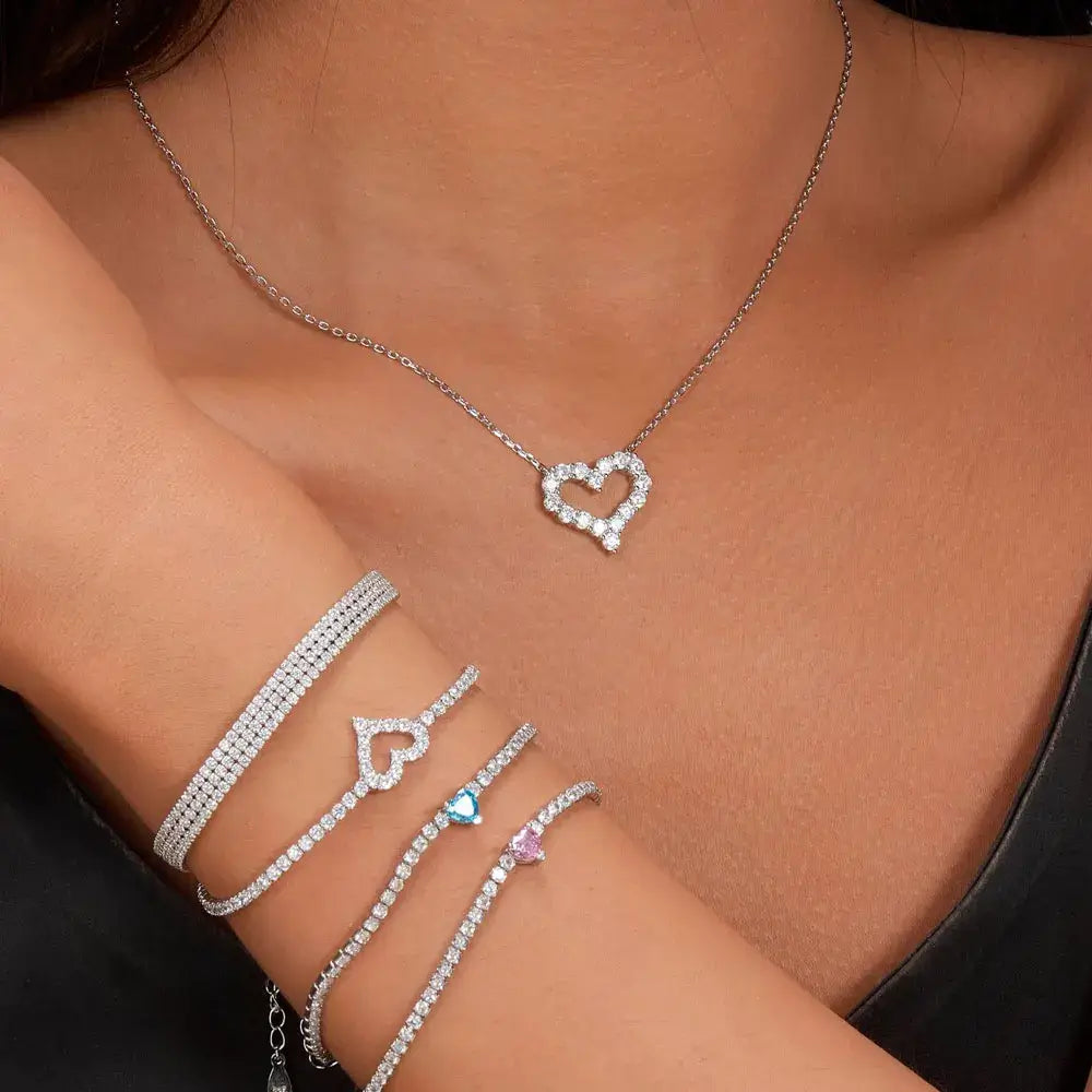 Elegant heart pendant necklace accompanied by sparkling bracelets, perfect jewelry for women.