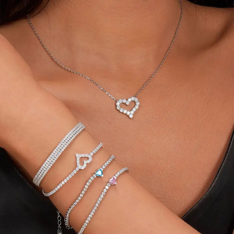 Elegant heart pendant necklace accompanied by sparkling bracelets, perfect jewelry for women.