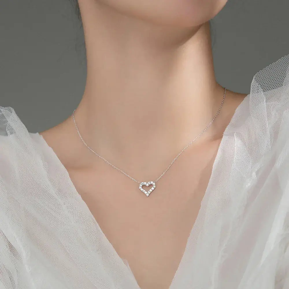 Elegant heart pendant necklace featuring sparkling moissanite, perfect gift for women, showcased against a soft fabric background.