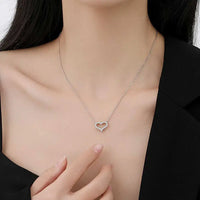 Heart pendant necklace with sparkling moissanite, showcasing elegant design on a woman's neck.