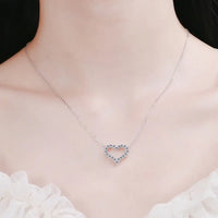 Moissanite heart pendant necklace on a model, showcasing sparkling stones and sterling silver design.