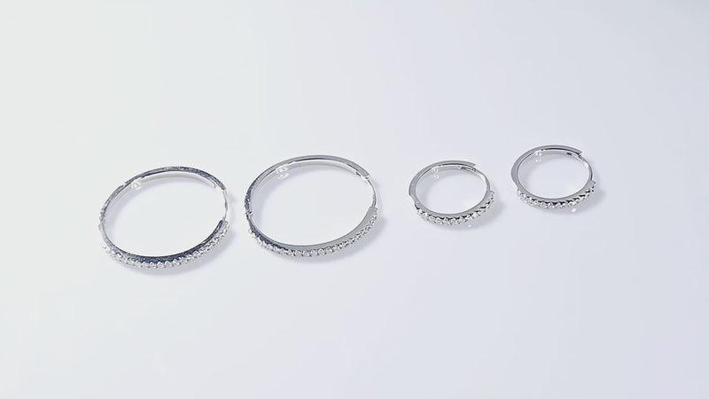 Close-up video of moissanite hoop earrings set in 925 sterling silver with white gold plating, showing sparkling round stones
